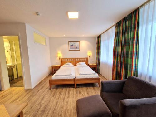 a hospital room with two beds and a couch at Badhotel Restaurant Stauferland in Bad Boll