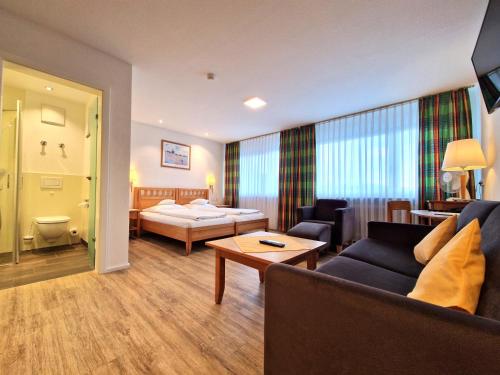 a living room with a couch and a bed at Badhotel Restaurant Stauferland in Bad Boll