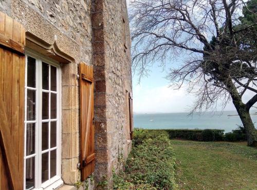 - une fenêtre d'un bâtiment en briques avec vue sur l'océan dans l'établissement Ar Maner - Grande maison familiale - 7 chambres - Jardin, à Crozon