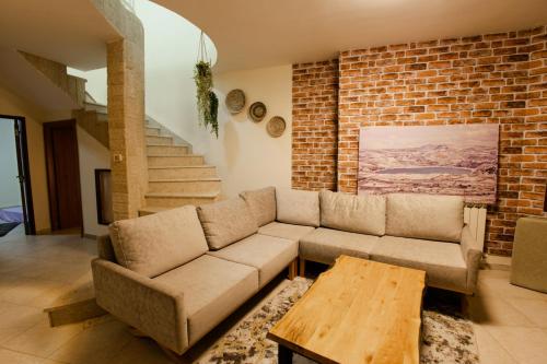 a living room with a couch and a brick wall at Ram La-nof in Majdal Shams