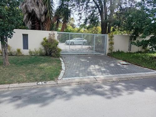 a driveway with a car parked behind a fence at 4C On Gillian in Sandton