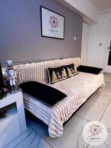 a couch with pillows on it in a room at Cseppecske Apartman in Pécs