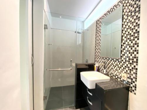 un bagno con lavandino e doccia con specchio di Coast Boutique Hotel a Kuta