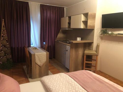 Zimmer mit einem Bett und einer Küche mit einem Schreibtisch in der Unterkunft Apartments Dunja in Novi Sad