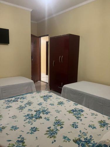 a bedroom with two beds and a dresser in it at Pousada Beira Rio Barreiras in Barreiras