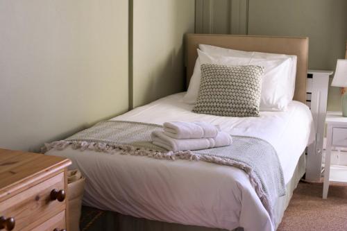 a bedroom with a bed with towels on it at Hawkwood in Stroud