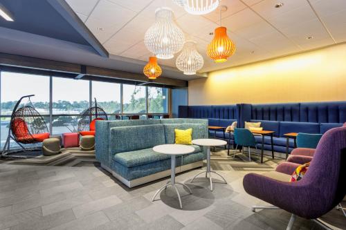 a waiting room with chairs and tables and windows at Tru By Hilton Panama City Beach in Panama City Beach