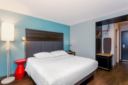 a bedroom with a white bed and a red stool at Tru By Hilton Panama City Beach in Panama City Beach