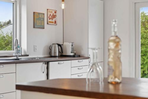 a kitchen with a bottle of wine on a counter at Lovely Secluded Cottage In Dronningmølle in Dronningmølle