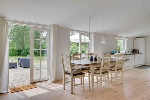 a kitchen and dining room with a table and chairs at Lovely Secluded Cottage In Dronningmølle in Dronningmølle