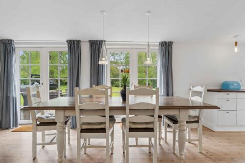 a dining room with a wooden table and chairs at Lovely Secluded Cottage In Dronningmølle in Dronningmølle