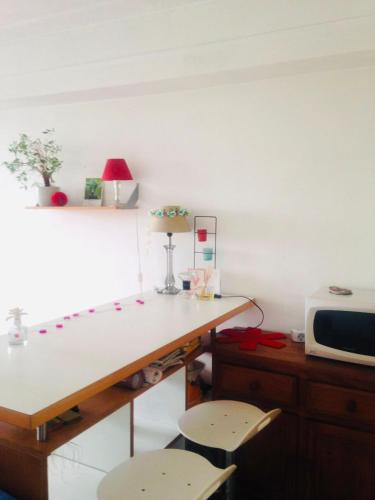 - une cuisine avec un bureau, 2 chaises et un four micro-ondes dans l'établissement Amazing Eiffel views at cool central area, à Paris