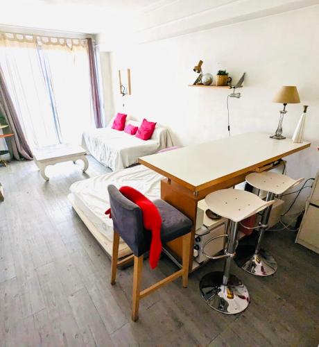 Cette chambre comprend un bureau, une table et un canapé. dans l'établissement Amazing Eiffel views at cool central area, à Paris