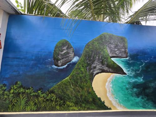 a painting of a beach and rocks on a wall at Kelingking BMS Penida Hills Villa in Nusa Penida