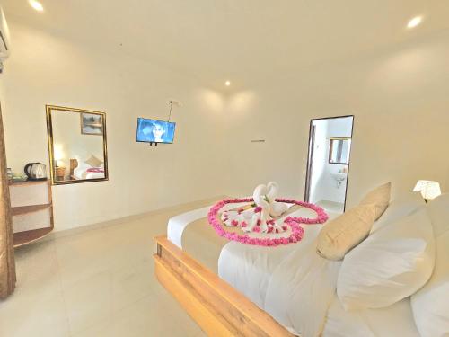 a bedroom with a bed with a flower on it at Kelingking BMS Penida Hills Villa in Nusa Penida