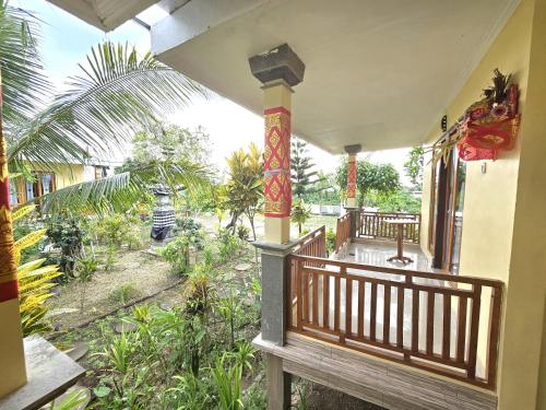 a balcony of a house with a view of a garden at Kelingking BMS Penida Hills Villa in Nusa Penida