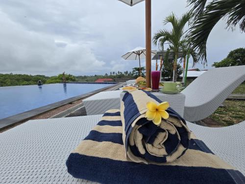 a table with a towel on top of it next to a pool at Kelingking BMS Penida Hills Villa in Nusa Penida