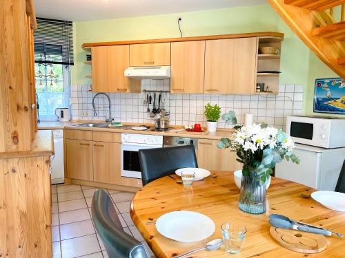a kitchen with a wooden table with a vase of flowers at Ferienhaus Bach in Dorum Neufeld
