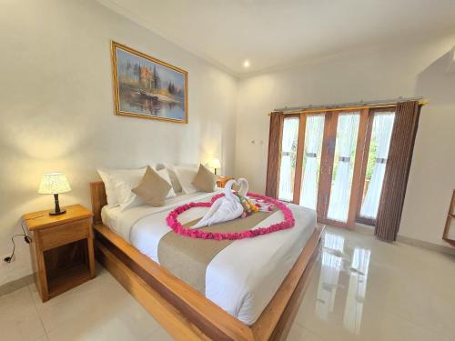 a bedroom with a bed with a wreath on it at Kelingking BMS Penida Hills Villa in Nusa Penida