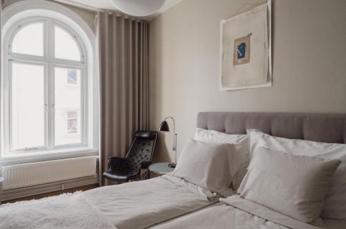 a bedroom with a bed with a window and a chair at TwentySix in Malmö