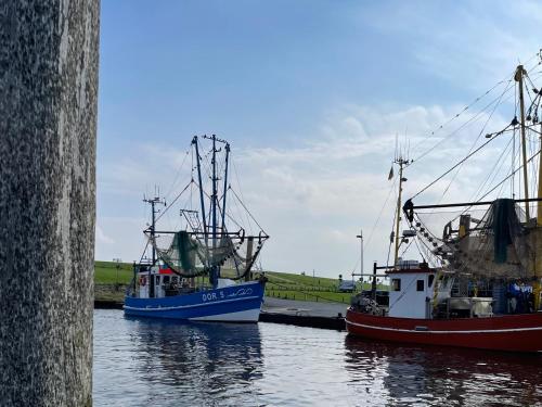 two fishing boats are docked in the water at Ferienhaus Bach in Dorum Neufeld