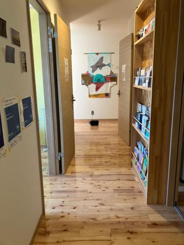 a hallway of an art gallery with a wooden floor at Shioya Hostel in Akune