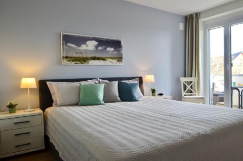 a bedroom with a large bed and a window at Ferienwohnung de Hasel in Dorum Neufeld