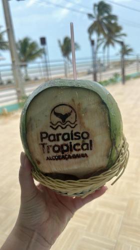 a person holding up a basket with a sign that reads paraisolis tortilla at Hotel Paraiso Tropical in Alcobaça