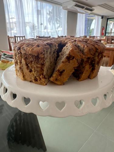 a cake sitting on top of a plate on a table at Hotel Paraiso Tropical in Alcobaça
