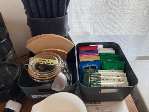 a lunch box with books and a jar on a desk at Shioya Hostel in Akune