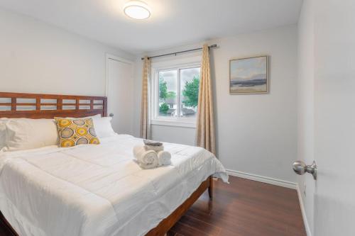 a bedroom with a large white bed with a window at Whitby Family Retreat Comfort and Convenience in Whitby