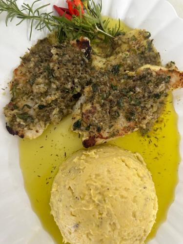 a plate of food with meat and a biscuit at Hotel Paraiso Tropical in Alcobaça