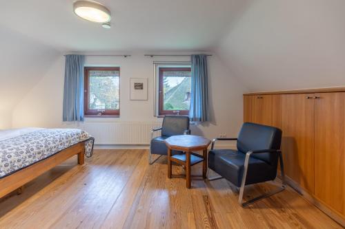 a bedroom with a bed and two chairs and a table at Dat Reethuus in Böhl