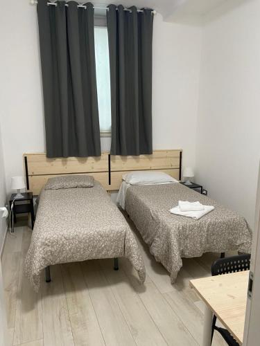 a room with two beds and a window at Low Cost Ferrara in Ferrara