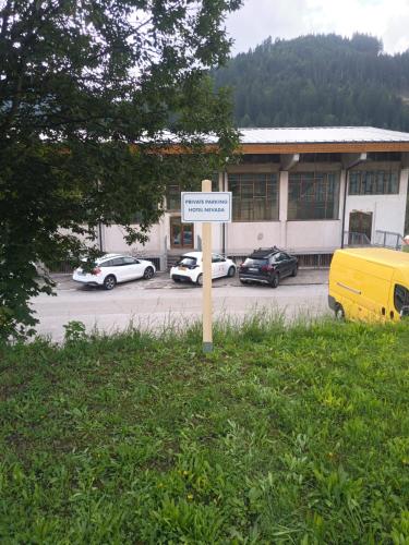 a sign in the grass in front of a parking lot at Best Western Hotel Nevada in San Vito di Cadore