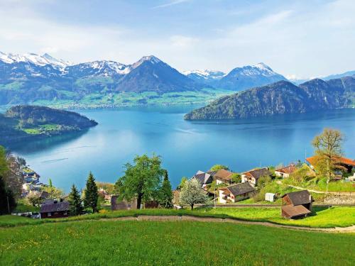 a village on a lake with mountains in the background at Chalet Oz in Vitznau