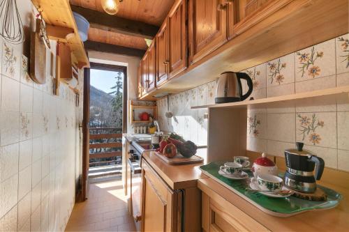 a kitchen with wooden cabinets and a counter top at Appartamento Beau Soleil - Happy Rentals in Sauze d'Oulx