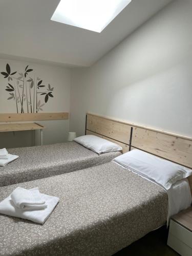 two beds in a room with two white towels at Low Cost Ferrara in Ferrara