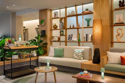 a living room with a couch and tables and shelves at Element by Westin Wroclaw in Wrocław