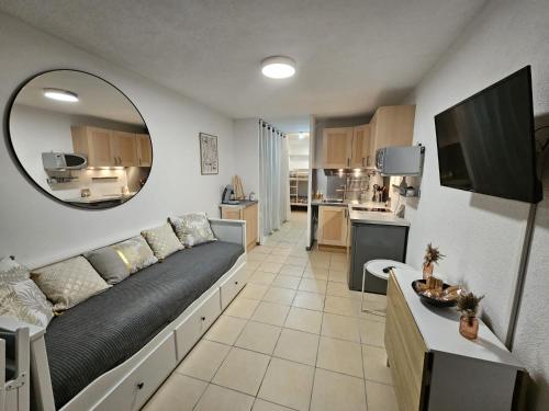 un salon avec un canapé et un grand miroir dans l'établissement L'écrin du lac, au Barcarès