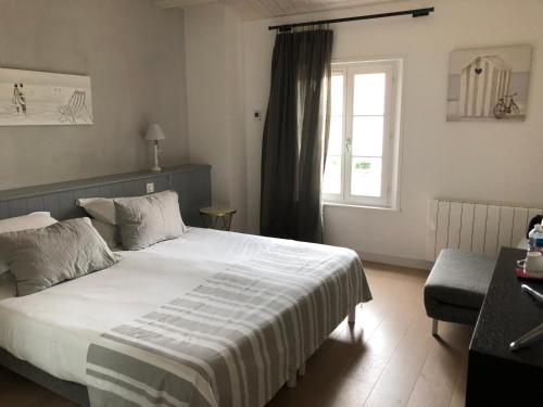 a bedroom with a large bed and a window at Le Clos Du GALION - Ile de Ré in Saint-Martin-de-Ré