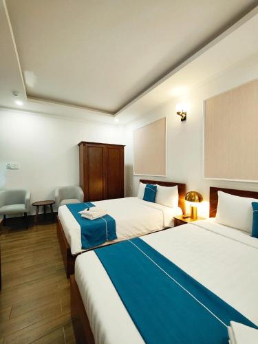 a hotel room with two beds with blue sheets at Hodota Ankroet Hotel & Spa in Da Thanh