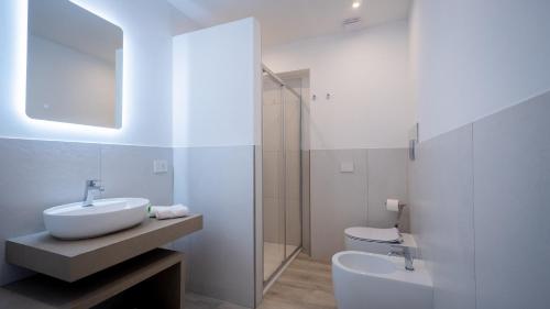 a white bathroom with a sink and a toilet at Modern Room in Olbia