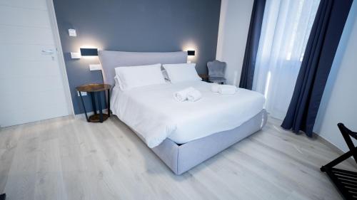 a bedroom with a white bed with two towels on it at Modern Room in Olbia