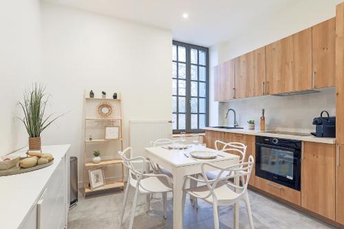 - une cuisine avec une table blanche et des chaises blanches dans l'établissement La Maison du Gardien, à Brignais