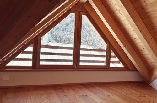 a room with a large window in a attic at Mountain Exzelent Residence in Anterselva di Mezzo