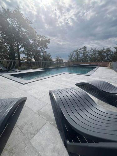 une piscine avec un banc devant dans l'établissement Gîte de Combe Falce, à Salignac Eyvigues