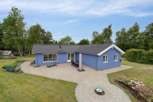 a blue shed with a patio in a yard at Lovely Holiday Home In Nykøbing Sjælland in Nyrup