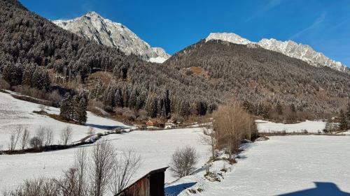 a snow covered mountain range with a house in the foreground at Mountain Exzelent Residence in Anterselva di Mezzo