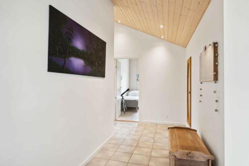 a hallway with a bench and a tv on the wall at Lovely Holiday Home In Nykøbing Sjælland in Nyrup